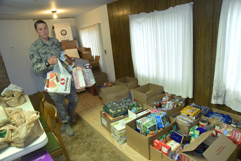 Staff Sgt. Oceana Goodsell, 50th Security Forces Squadron, brings in food collected from the Schriever Kids Helping Kids food drive to the Ellicott Helping Hands Food Pantry in Ellicott, Colorado, Tuesday, May 9, 2017. Food collected included canned goods, cereals and pasta, among other items for local Ellicott families. (U.S. Air Force photo/Airman 1st Class William Tracy)