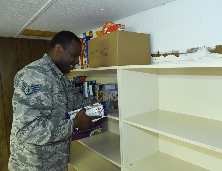 Staff Sgt. James Porter, 50th Security Forces Squadron, stocked shelves with donated items in the Ellicott Helping Hands Food Pantry in Ellicott, Colorado, Tuesday, May 9, 2017. After all the donated food items were brought in, the shelves, floor panels and center table were lined with various food products for local families in need. (U.S. Air Force photo/Airman 1st Class William Tracy)