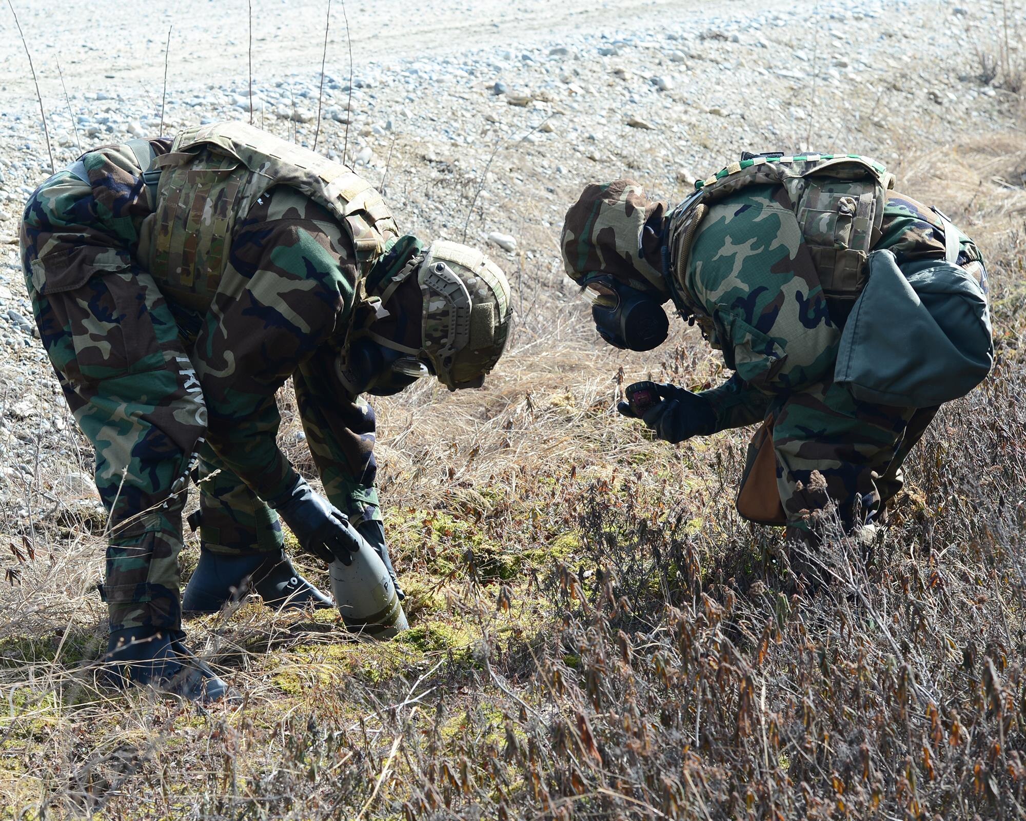 U.S. Air Force Senior Airman Thomas Pryzbylek, a 354th civil engineer squadron (CES) explosive ordnance disposal (EOD) team member, holds a simulated unexploded ordnance, while Staff Sgt. Cody Miller, a 354th CES EOD team leader, photographs it’s markings during Operation Merlin Wing, May 5, 2017 at Eielson Air Force Base, Alaska. EOD uses photos of markings on explosives to help them identify what measures must be taken to ensure safety. (U.S. Air Force photo by Airman Eric M. Fisher)