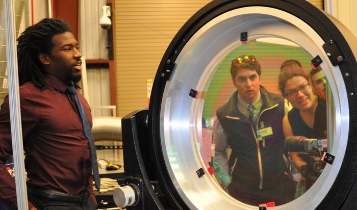 DAHLGREN, Va. (April 26, 2017) - Roger Campbell, a Navy lethality engineer, explains the Laser Lethality and Development lab capabilities to undergraduate and graduate students touring Naval Surface Warfare Center Dahlgren Division (NSWCDD) during the annual Naval Engineering Education Consortium (NEEC) meeting.  The students are looking through a 16" optic lens - part of the NSWCDD Laser Technology and  Analysis Branch laboratory's optics layout - used for evaluating laser effectiveness against various materials. 

