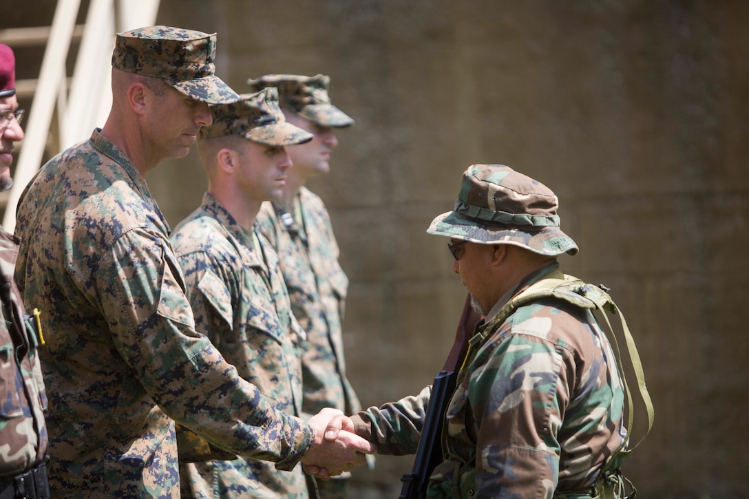 CAMP LEJEUNE, N.C. – Maj. Robert G. Gill congratulates a role player at a simulated graduation ceremony during General Exercise 2 at Marine Corps Base Camp Lejeune, North Carolina, May 4, 2017. The Marines conducted the final rehearsal exercise of the Marine Advisor Course in order to assess their readiness to train foreign security forces during their upcoming deployment to Central America. Gill is the officer in charge of the Ground Combat Element, Special Purpose Marine Air-Ground Task Force - Southern Command. The Marine Advisor Course is taught by the Marine Corps Security Cooperation Group. (U.S. Marine Corps photo by Sgt. Ian Leones)