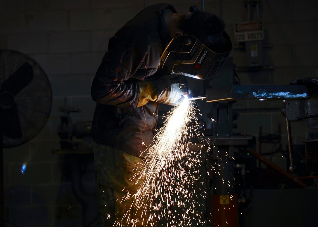 U.S. Army Spc. Anthony Cole, 558th Transportation Company, 10th Battalion, 7th Transportation Brigade (Expeditionary) allied trade specialist, welds metal rods together at Joint Base Langley-Eustis, Va., May 4, 2017. Cole fabricated bottle-rack-holders for oxygen tanks, which can be dangerous if not secured properly. (U.S. Air Force photo/Airman 1st Class Kaylee Dubois)