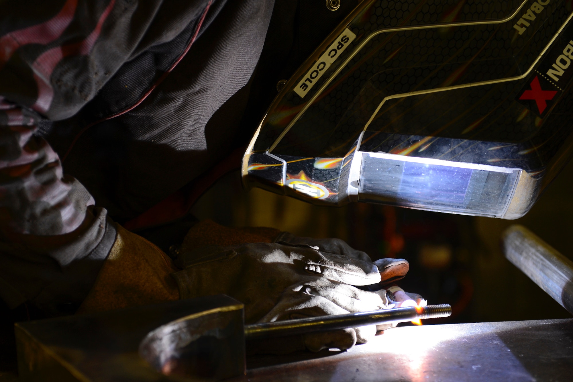 U.S. Army Spc. Anthony Cole, 558th Transportation Company, 10th Battalion, 7th Transportation Brigade (Expeditionary) allied trade specialist, welds a bolt to a metal rod at Joint Base Langley-Eustis, Va., May 4, 2017. Cole spent a week building the fixture completely by hand, ensuring every groove and bolt was perfectly aligned. (U.S. Air Force photo/Airman 1st Class Kaylee Dubois)
