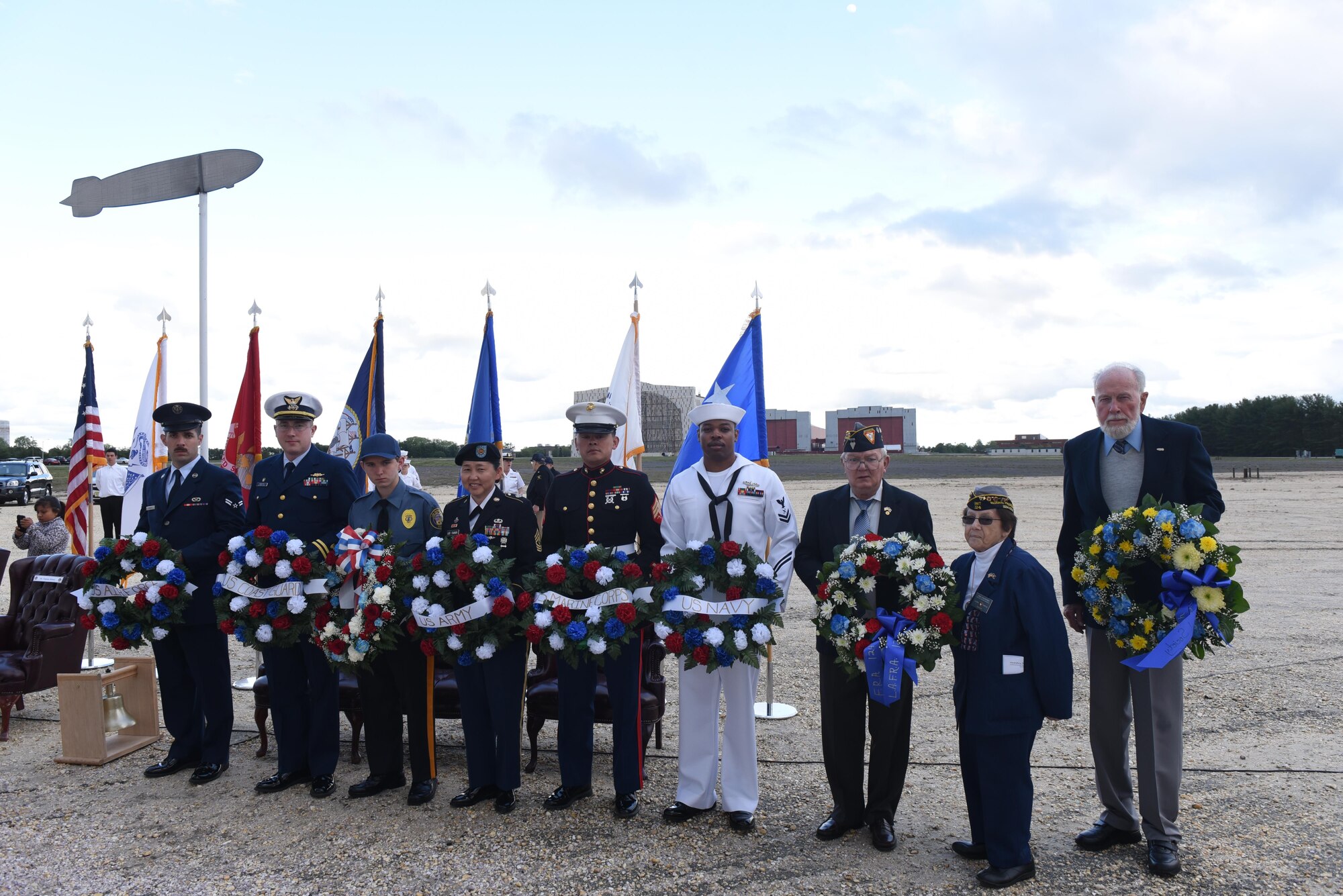 Servicemembers from each military branch, the local police department, members of the veteran association and community members present a wreath at the Hindenburg memorial at Joint Base McGuire-Dix-Lakehurst, New Jersey, May 6, 2017. The event including the U.S. Navy tradition of the passing bell and the playing of Taps. 