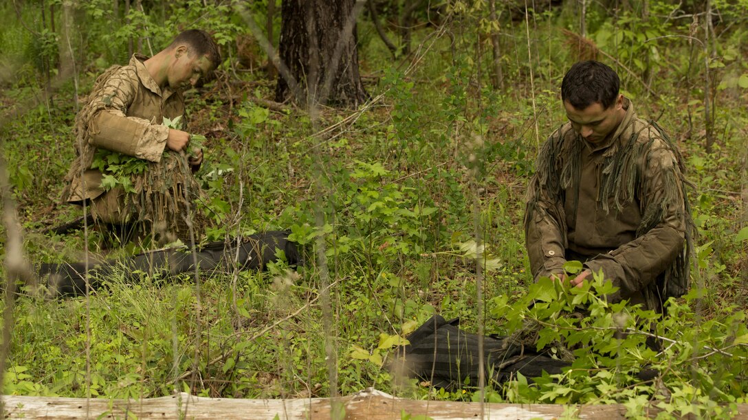 Marines weave vegetation into their ghillie suits before the commencement of stalk training during a training exercise at Fort A.P. Hill, Va., April 26, 2017. Marines conducted the training in preparation for an upcoming deployment as a crisis response force. The Marines are with 2nd Battalion, 2nd Marine Regiment.