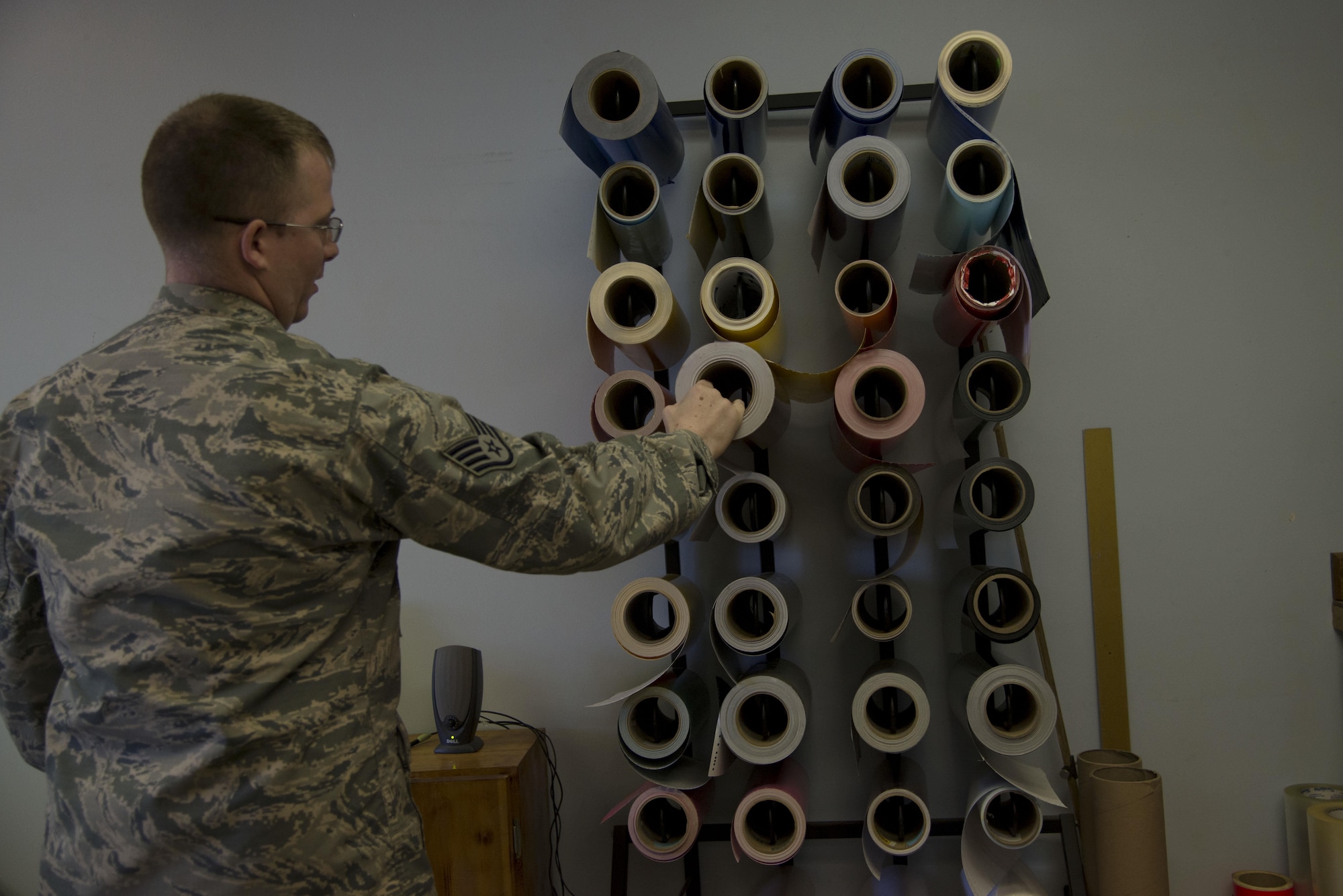 Staff Sgt. Horace Hand, 5th Civil Engineer Squadron structural craftsman, pulls out a roll of vinyl at Minot Air Force Base, N.D., April 27, 2017. The sign shop produces about 20-25 signs per week. (U.S. Air Force photo/Airman 1st Class Dillon Audit)