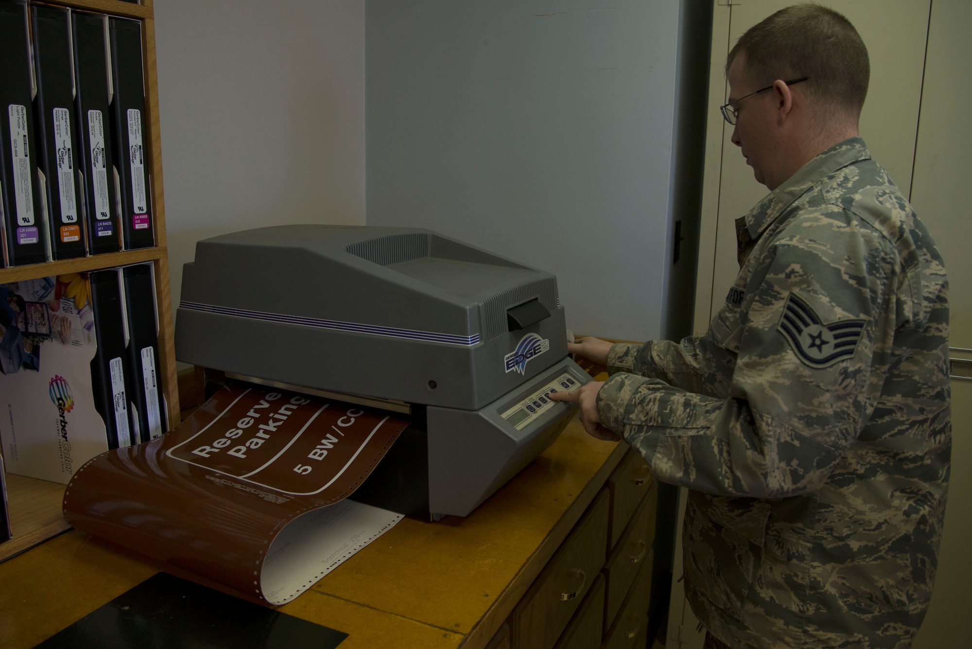 Staff Sgt. Horace Hand, 5th Civil Engineer Squadron structural craftsman, prints a sign at the sign shop on Minot Air Force Base, N.D., April 27, 2017. Thermal printers are used to produce images by selectively heating coated paper when passed over the print head. (U.S. Air Force photo/Airman 1st Class Dillon Audit)