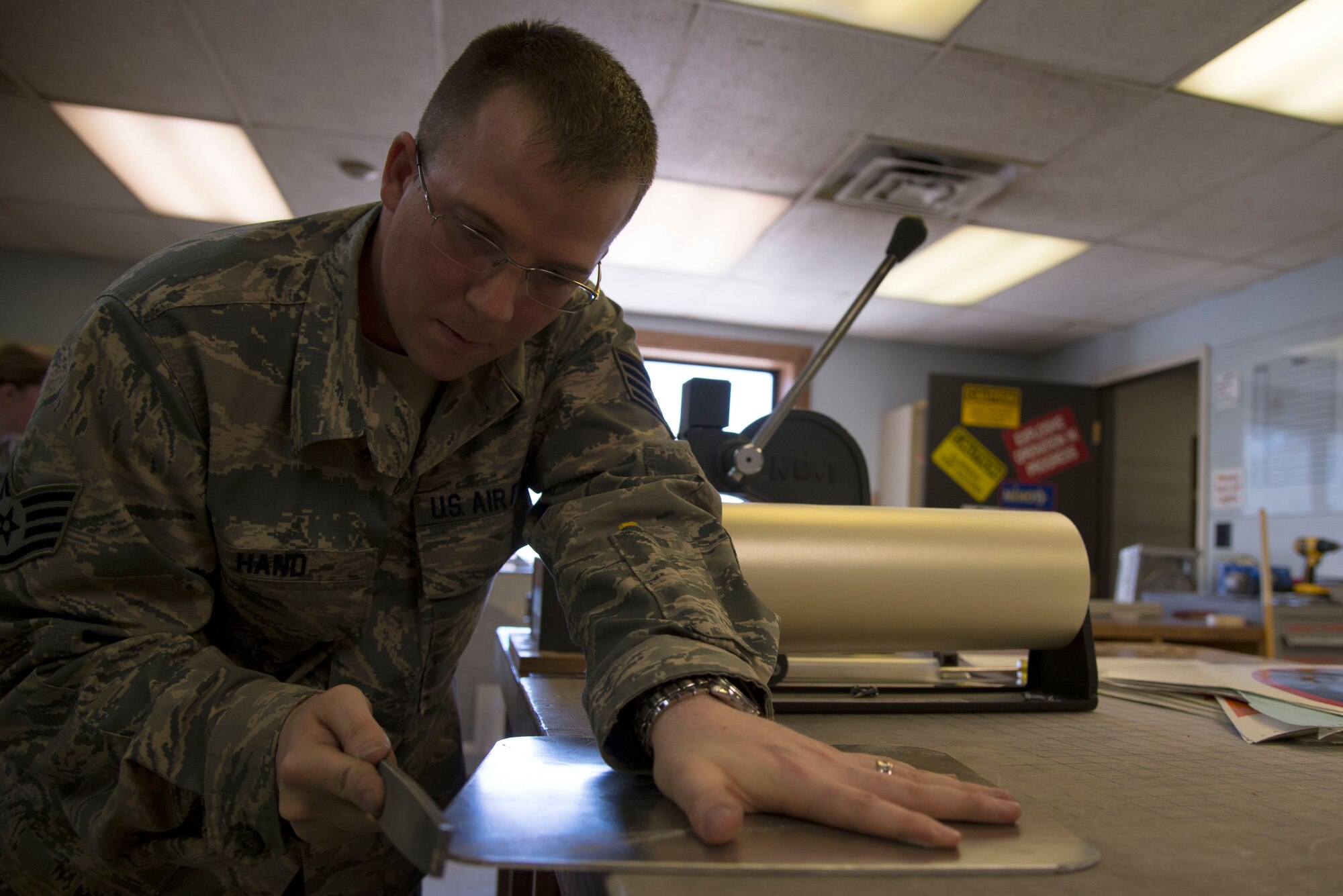 Staff Sgt. Horace Hand, 5th Civil Engineer Squadron structural craftsman, files metal at the sign shop on Minot Air Force Base, N.D., April 27, 2017. Filing edges makes a smoother sign and helps the vinyl last longer. (U.S. Air Force photo/Airman 1st Class Dillon Audit)