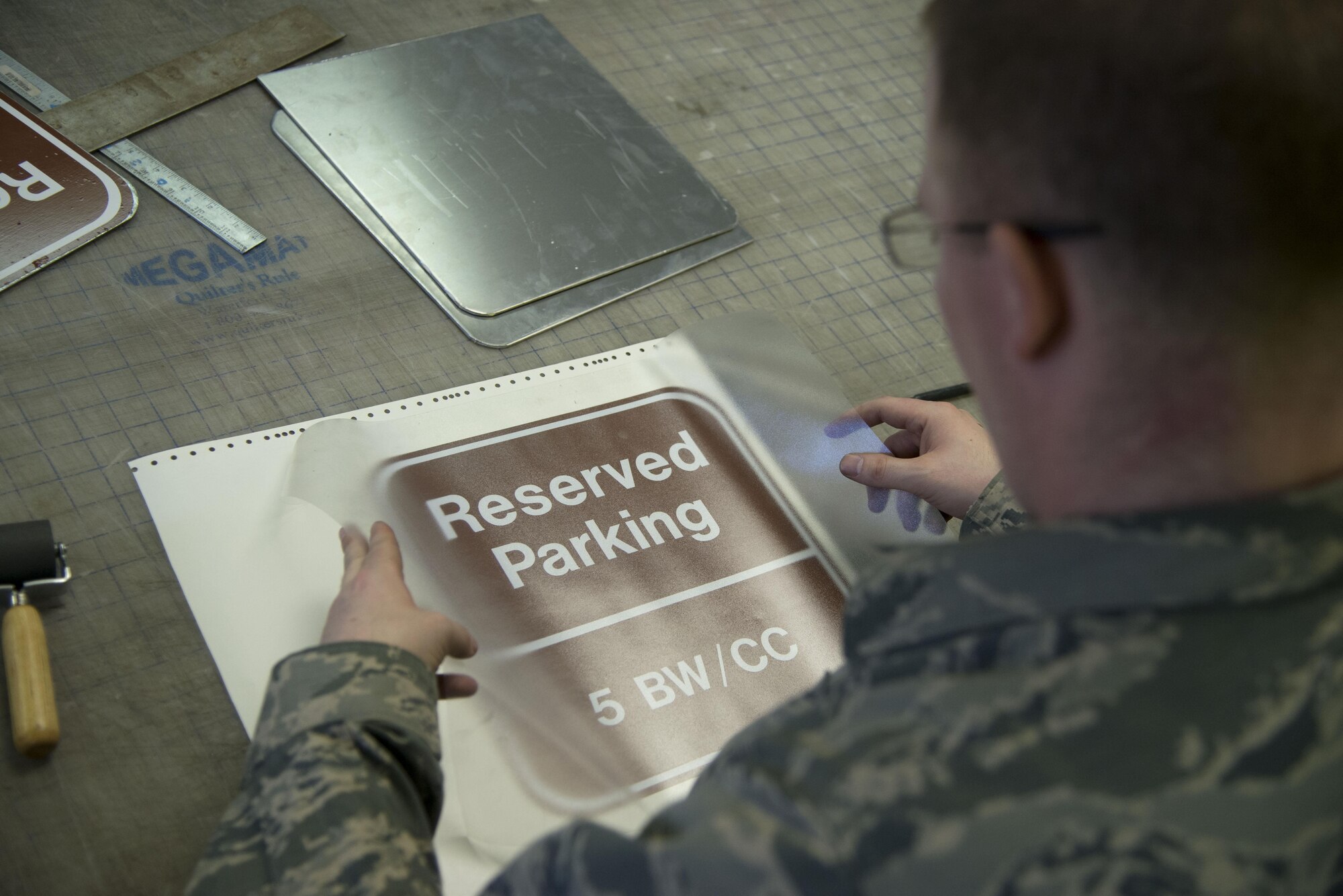 Staff Sgt. Horace Hand, 5th Civil Engineer Squadron structural craftsman, applies transfer paper to a sign at the sign shop on Minot Air Force Base, N.D., April 27, 2017. The sign shop produces about 20-25 signs per week. (U.S. Air Force photo/Airman 1st Class Dillon Audit)