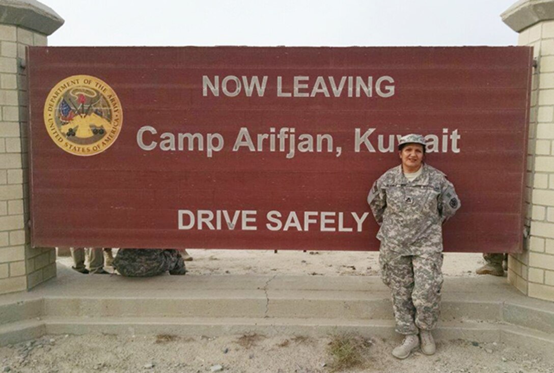 Amelia Stanko, contracting officer, Supply Operations Commodities Directorate, Defense Logistics Agency Aviation, poses next the exit sign for Camp Afrifjan, Kuwait as she ends her DLA Support Team deployment July 26, 2015.