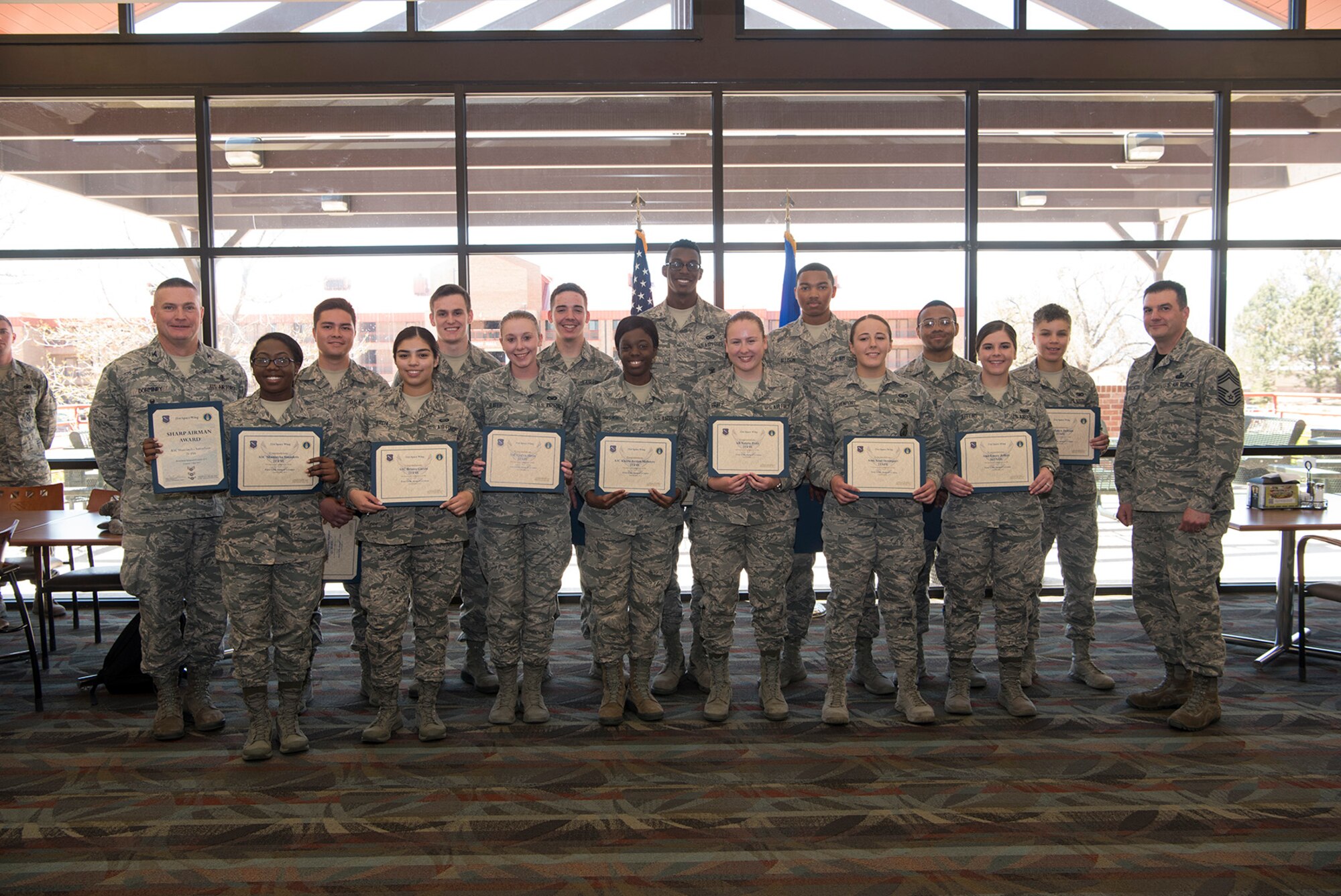 The newest class of first term Airmen stand alongside with Col. Eric Dorminey, 21st Space Wing vice commander (far left) and Chief Master Sgt. Vincent Persichetti, 21st Mission Support Group chief (far right) at the First Term Airman Center hand-off luncheon in the Aragon dining facitly at Peterson Air Force Base, Colo. on May 5, 2017. The FTAC luncheon is held at the end of the FTAC course that provides new Airmen with briefings on financial responsibility, standards, discipline, and more lessons to prepare them to work in their new unit. (U.S. Air Force photo by Steve Kotecki)
