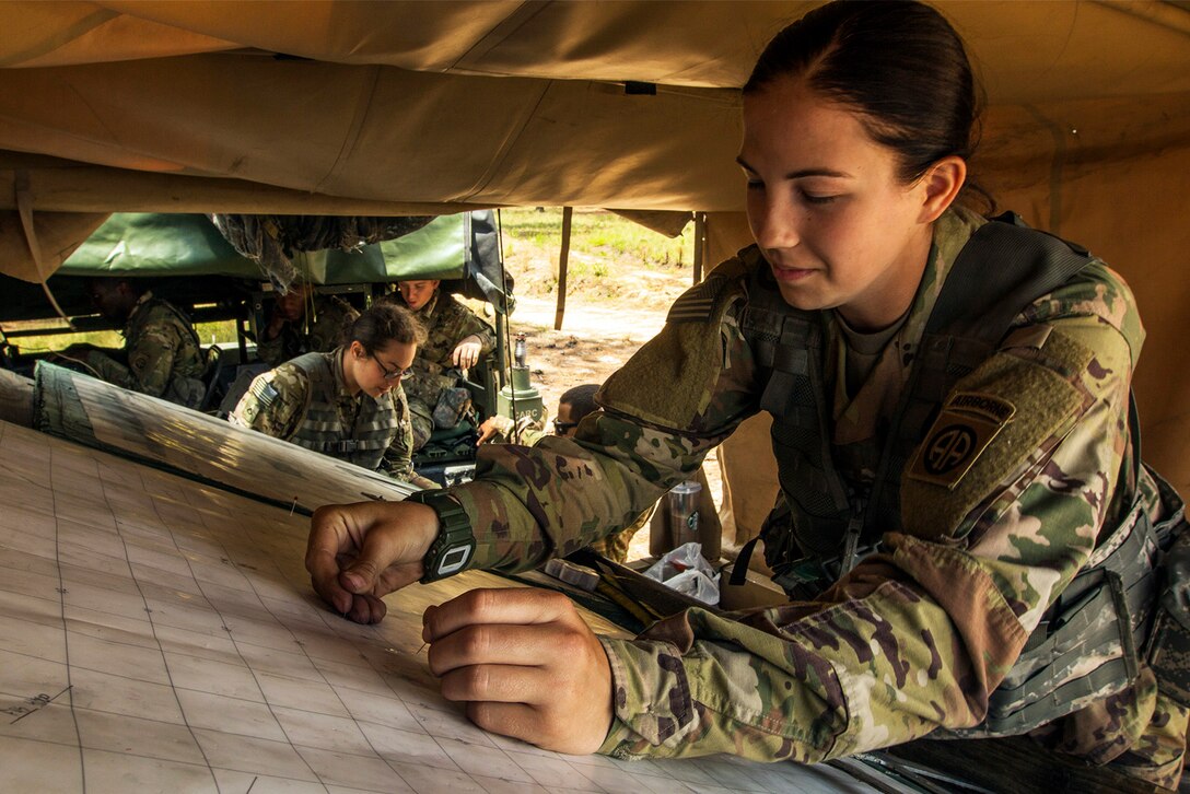 Army Pvt. Adaline Nelson plots grid points to find the range of a simulated target on a chart during a field training exercise at Fort Bragg, N.C., May 5, 2017. The field training exercise served to prepare the section for an upcoming field artillery qualification. Army photo by Spc. L'Erin Wynn