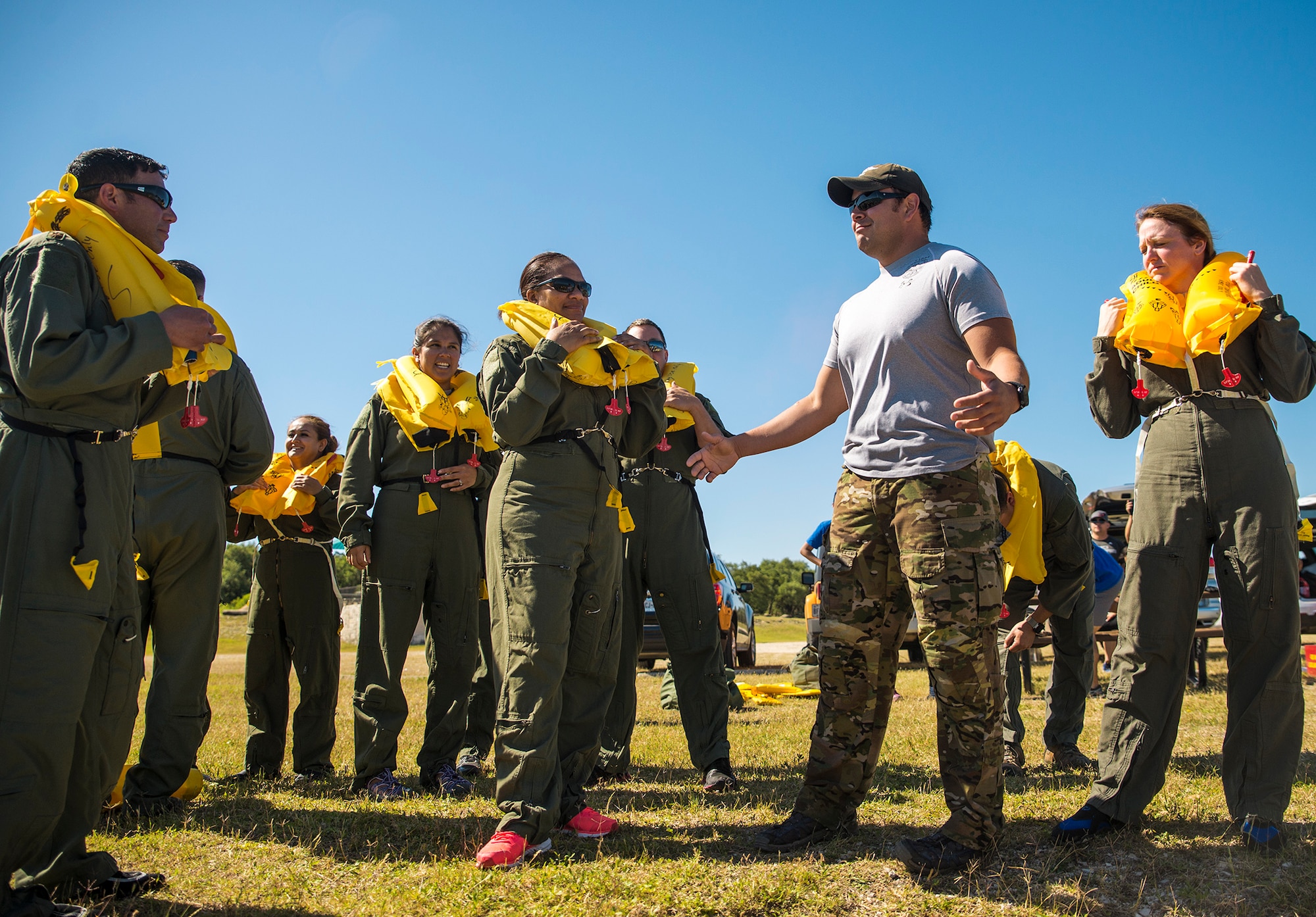 Tech. Sgt. Justin Samaniego, 433rd Operation Support Squadron survival evasion resistance and escape instructor, discusses open water rescue and recovery techniques with Airmen from the 433rd Aeromedical Evacuation Squadron during water survival training May 5, 2017 at Joint Base San Antonio-Canyon Lake. The triannual training is a requirement for all aircrew Air Force Specialty Codes and includes open water swimming and life raft training. (U.S. Air Force photo by Benjamin Faske)