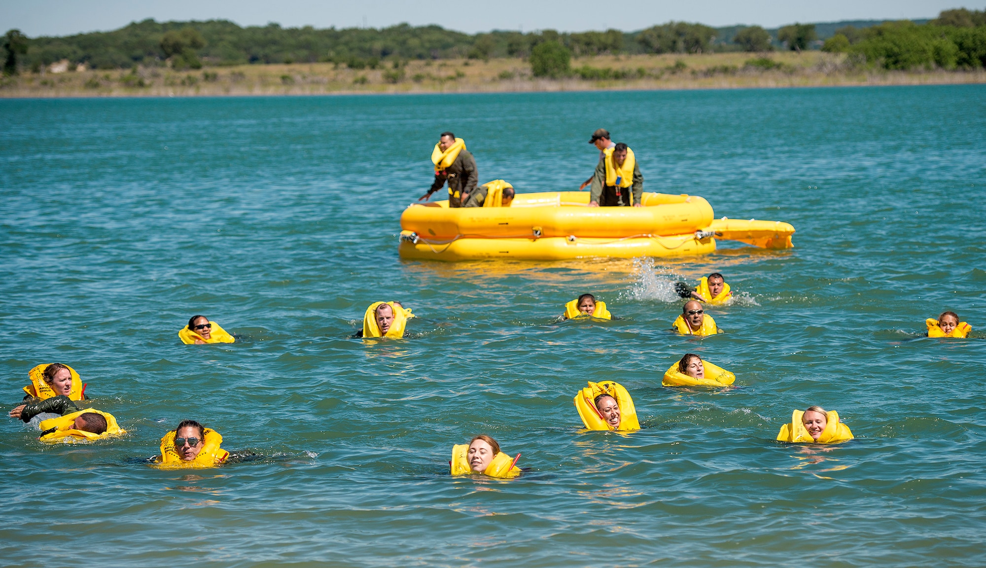Airmen from the 433rd Aeromedical Evacuation Squadron exit the 25-man life raft and swim to shore during water survival training May 5, 2017 at Joint Base San Antonio-Canyon Lake. The triannual training is a requirement for all aircrew Air Force Specialty Codes and includes open water swimming and life raft training. (U.S. Air Force photo by Benjamin Faske)