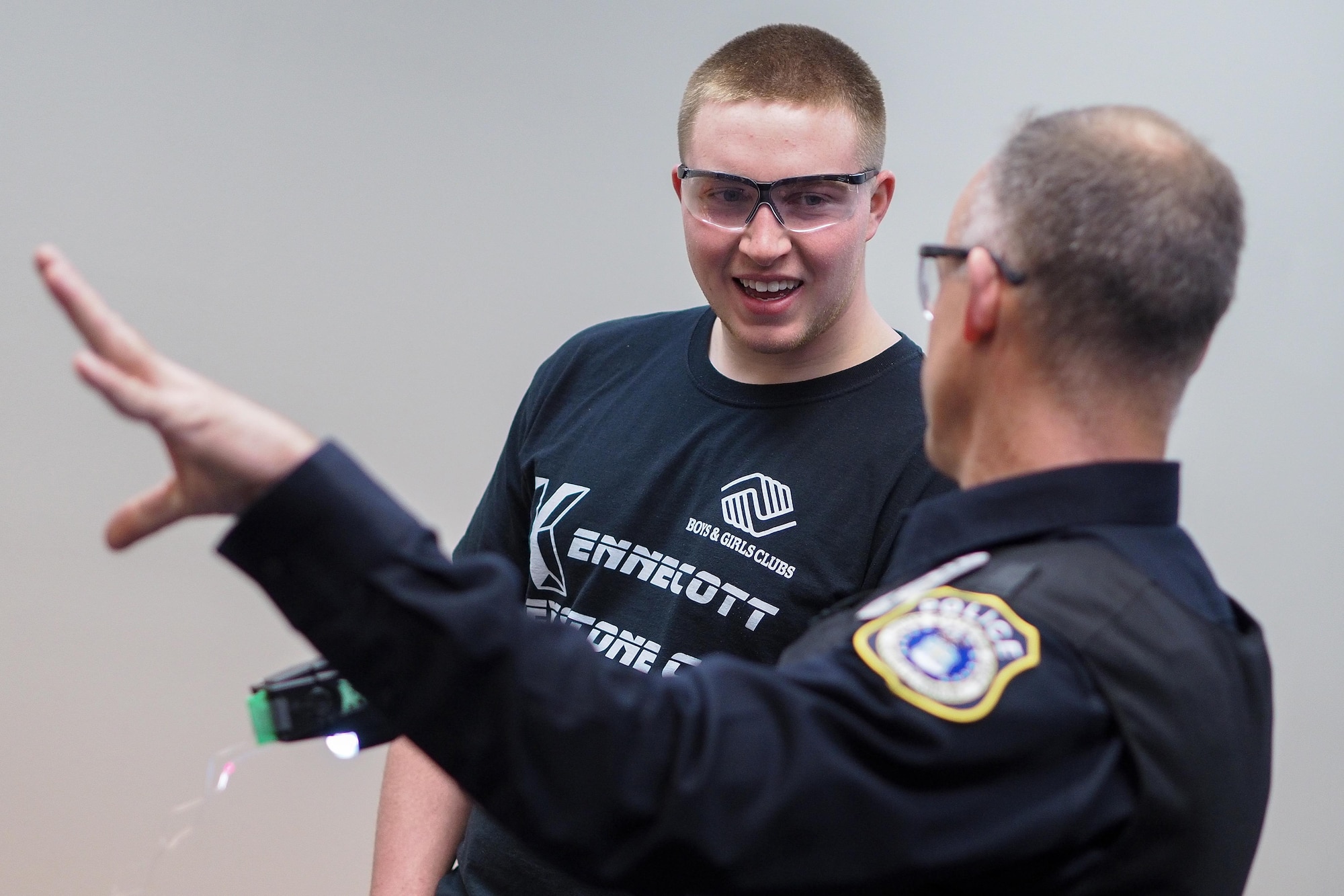 Officer Scott Garner, Joint Base Elmendorf-Richardson civilian police officer, talks to Aaron Regevig, Bartlett High School student, on security forces training measures during a job-shadowing program, May 4, 2017. (U.S. Air Force photo/Justin Connaher)
