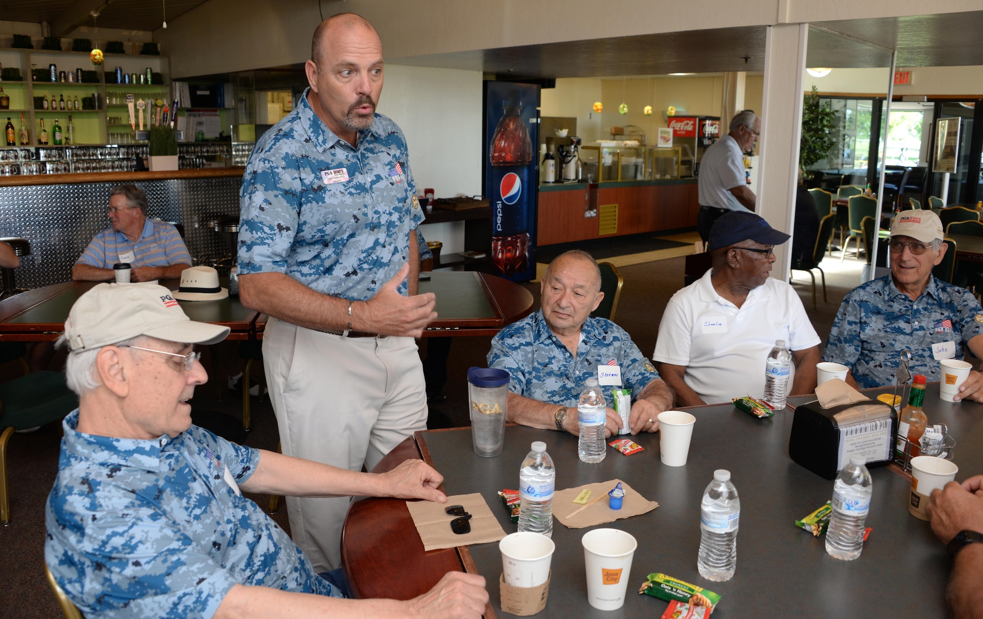 Jesse Walker, a Professional Golfers Association instructor, meets with military veterans before the start of the PGA's Helping Our Patriots Everywhere event May 5 at the Cypress Lakes Golf Course in Vacaville, Calif. Dozens of veterans attended the event designed to teach golf skills and bring prior service members together. (U.S. Air Force photo/Tech. Sgt. James Hodgman/Released)