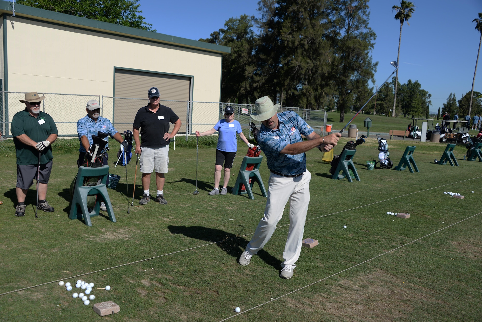 Jesse Walker, a Professional Golfers Association instructor, demonstrates proper swing techniques during the PGA's Helping Our Patriots Everywhere event May 5 at the Cypress Lakes Golf Course in Vacaville, Calif. Dozens of veterans attended the event designed to teach golf skills and bring prior service members together. (U.S. Air Force photo/Tech. Sgt. James Hodgman/Released)