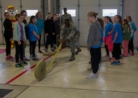 Staff Sgt. Shawn Vrock, 5th Civil Engineer Squadron crew chief, rolls a hose at the 5th CES fire station on Minot Air Force Base, N.D., May 1, 2017. Edison Elementary School’s science, technology, engineering and math girls received a firehouse tour and learned basic firefighter duties. (U.S. Air Force photo/Airman 1st Class Alyssa M. Akers)