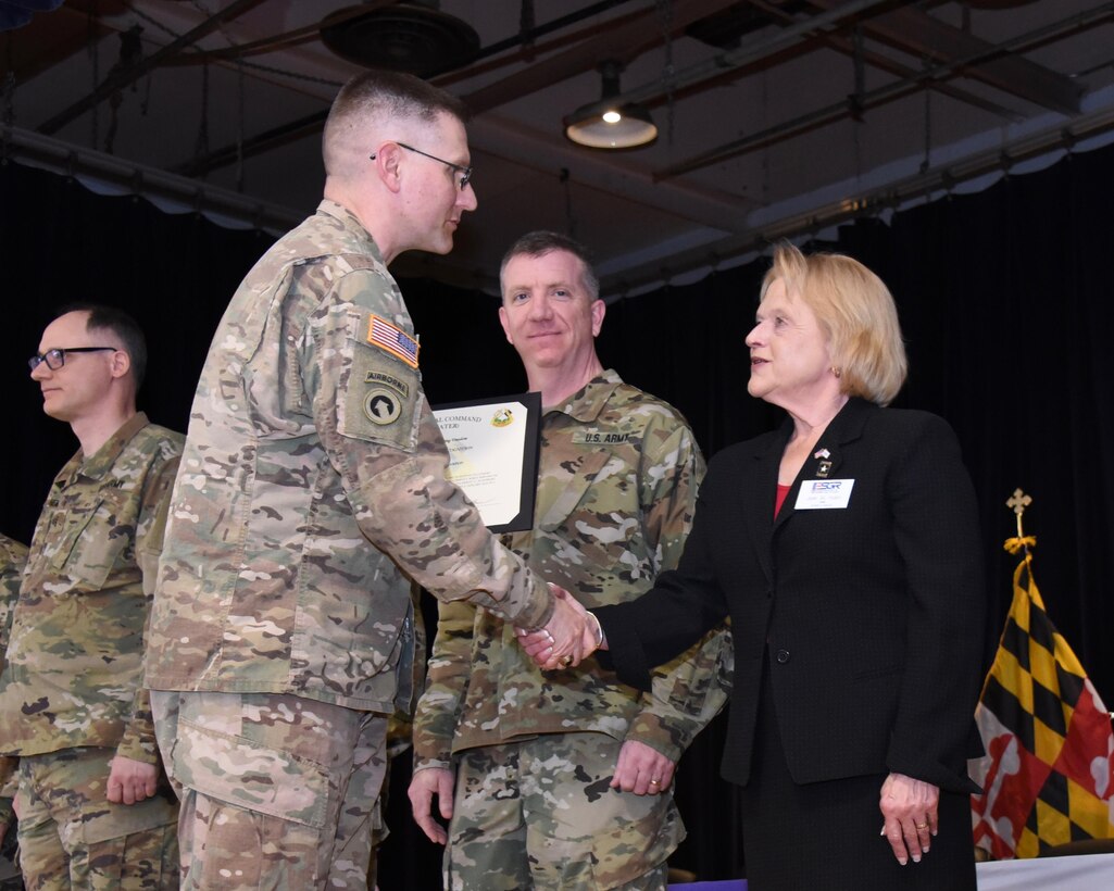 U.S. Army Lt. Col. William Bardon (left), commander of Detachment 21, Army Reserve Cyber Operations Group (ARCOG), 335th Signal Command (Theater), is congratulated by guest speaker, U.S. Army Col. Jean M. Hulet (Retired), State Chair for the Maryland Committee of the Employer Support of the Guard and Reserve, during a welcome home ceremony for the Detachment, April 2 at Fort Meade, Maryland. Detachment 21 was deployed to Kuwait as part of U.S. Army Central Command, to conduct cyber missions and training. (Courtesy photo by Joe Andrucyk)