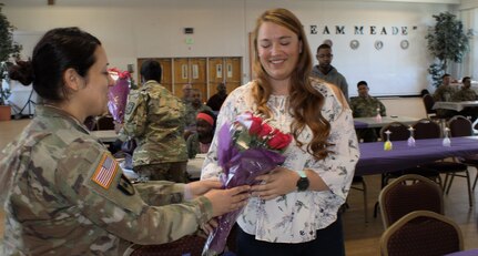 U.S. Army Sgt. Zahyra Yates, an Army Reserve Soldier assigned to the Army Reserve Cyber Operations Group (ARCOG), 335th Signal Command (Theater), presents flowers to a family member during a Welcome Home Warrior ceremony for Soldiers deployed from the ARCOG’s North Capital Region Cyber Protection Center, April 2 at Fort Meade, Maryland. The NCRCPC Soldiers were deployed to Kuwait to conduct cyber training and missions in support of U.S. Army Central Command. (U.S. Army Reserve Photo by Sgt. Erick Yates)