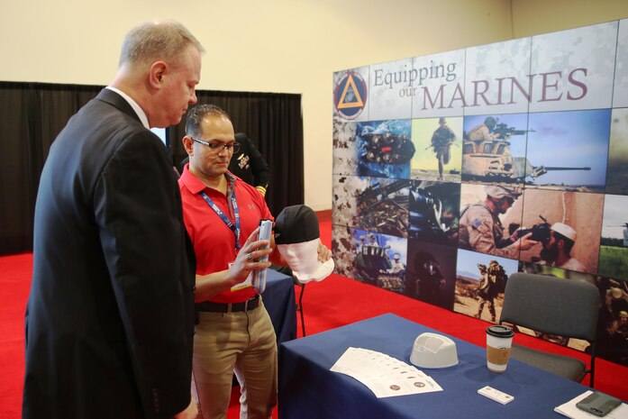 Mark Urrutic, project officer for Family of Field Medical Equipment Team at Marine Corps Systems Command, uses an Infrascanner to locate a simulated hematoma on a mannequin's skull while MCSC's Executive Director William Williford looks on at the Navy League's Sea Air Space Exhibition in National Harbor, Maryland, on April 3. The Infrascanner is a portable, medical diagnostic device that provides early detection of intracranial hematomas-or bleeding within the skull-in the field, potentially saving lives and improving casualty care and recovery. (U.S. Marine Corps photo by Ashley Calingo)