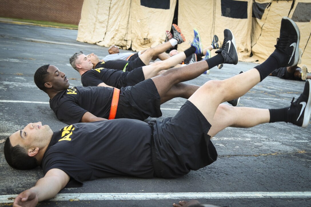 Soldiers from the 335th Signal Command (Theater), perform leg lift exercises during physical fitness training at the unit headquarters in East Point, Georgia May 10.  The event, hosted by Command Sgt. Maj. Ronnie Farmer, command sergeant major, 335th SC (T) included physical readiness training warm-ups, strength training and a 1.5 mile run.  (Official U.S. Army Reserve photo by Sgt. 1st Class Brent C. Powell)