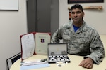 U.S. Air Force Master Sgt. Lallchan Seunarine, the 354th Medical Operations Squadron public health flight chief, poses with items from the Singapore Enlisted Officer Training Course May 5, 2017, at Eielson Air Force Base, Alaska. Seunarine’s syndicate team presented him with several items to memorialize their time learning together. 