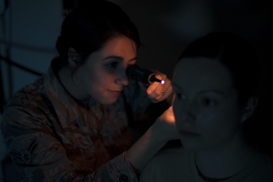 Senior Airman Kristen Aubrey, 23d Medical Operations Squadron aerospace medical technician, inspects a simulated patient's ear, May 4, 2017, at Moody Air Force Base, Ga. After recognizing a patient with life-threatening symptoms, Aubrey was honored for quickly responding to a potentially dire situation. (U.S. Air Force photo by Airman 1st Class Daniel Snider)