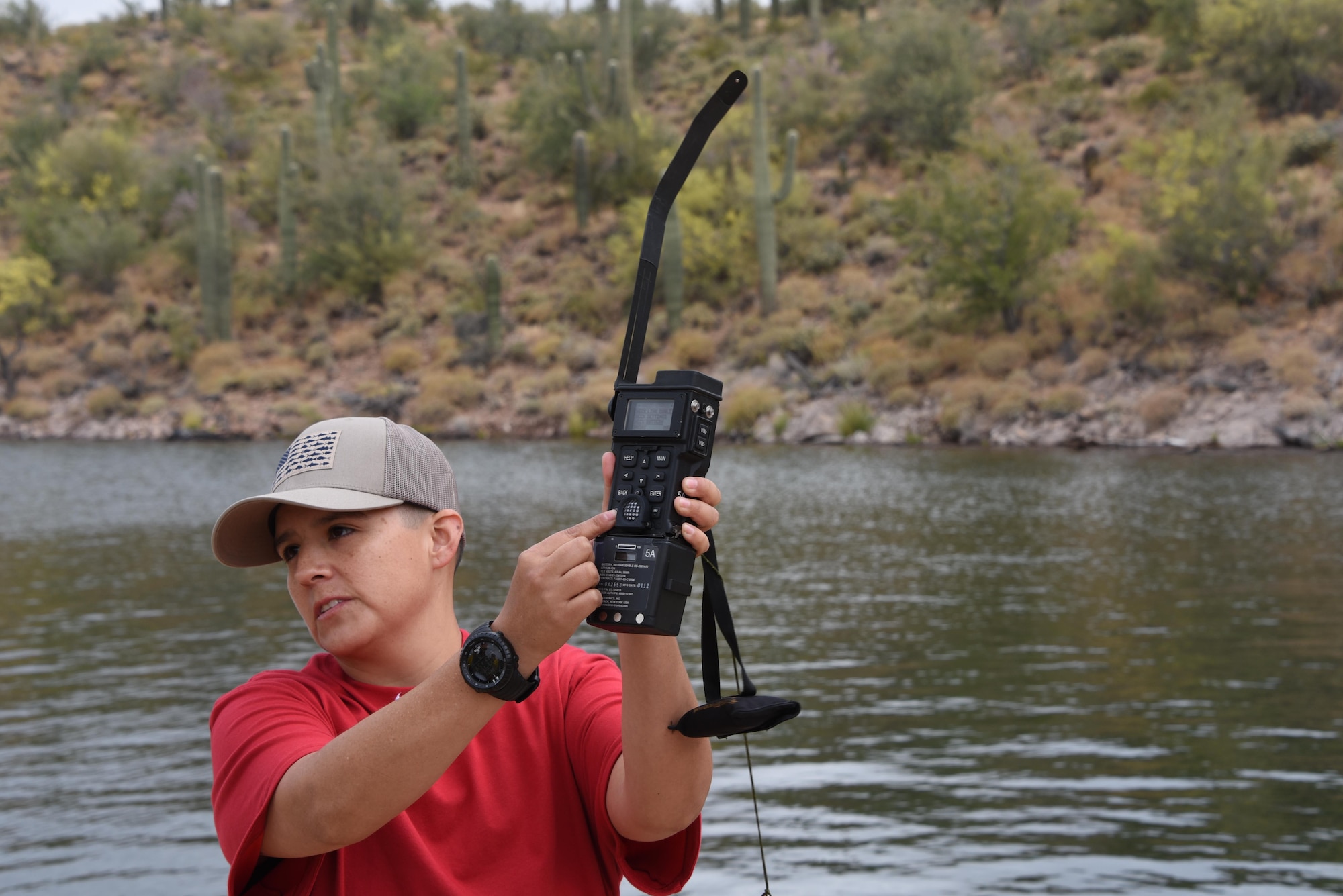 Master Sgt. Monica Martinez, an aircrew flight equipment specialist assigned to the 161st Air Refueling Wing,  demonstrates how to use the Combat Survival Evader Locater survival radio at water survival training at Lake Pleasant aquatic center, Ariz., May 7, 2017. The CSEL radio is used to contact the Joint Personnel Recovery Center in a survival situation. (U.S. Air Force photo by Tech. Sgt. Michael Matkin)