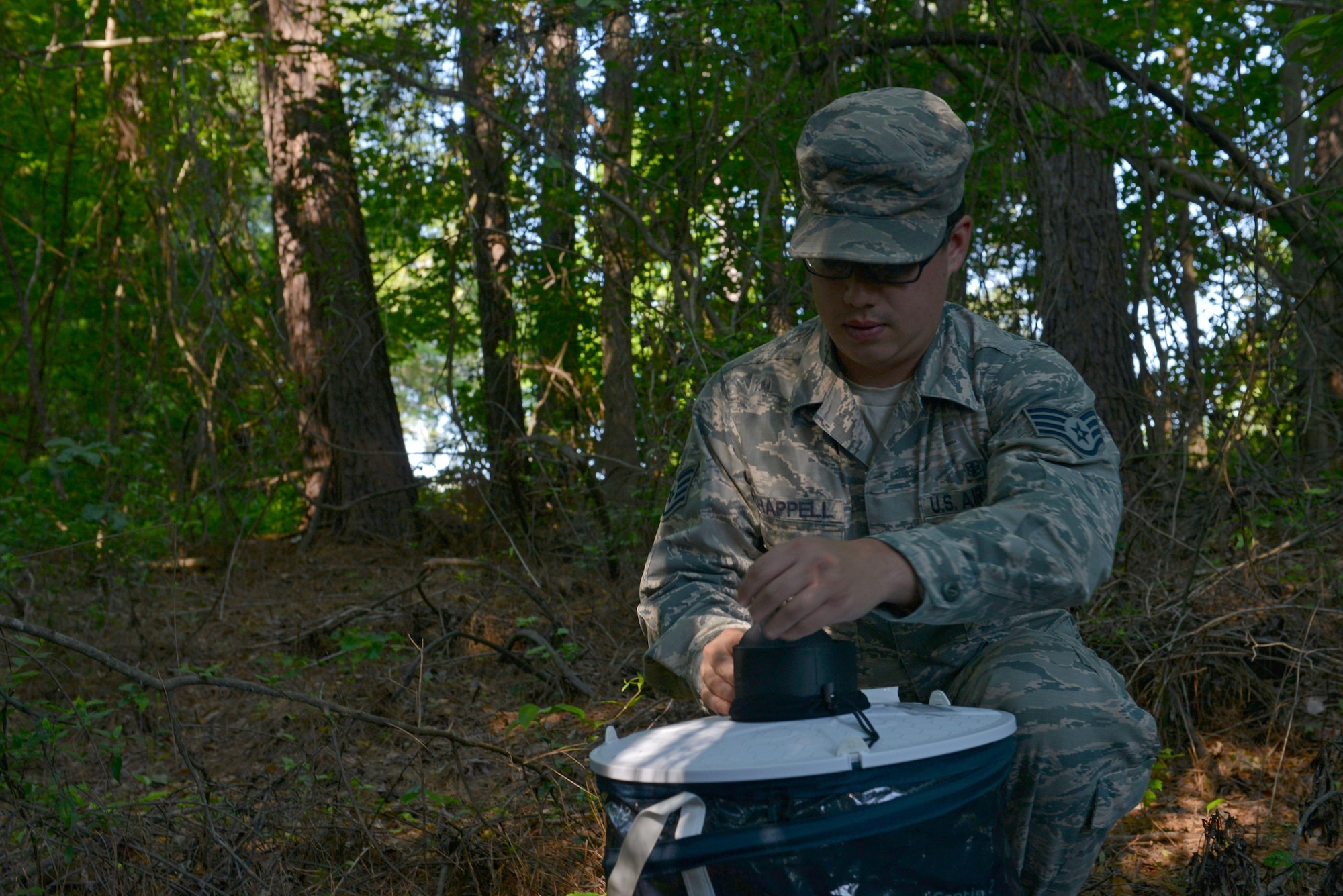 U.S. Air Force Staff Sgt. Michael Chapell, 20th Aerospace Medicine Squadron community health noncommissioned officer in charge, sets up a mosquito trap at Shaw Air Force Base, S.C., May 9, 2017. The mosquito trap will attract and contain insects, which the public health flight will then send to be tested for various diseases such as West Nile Virus and Zika. (U.S. Air Force photo by Airman 1st Class Destinee Sweeney)