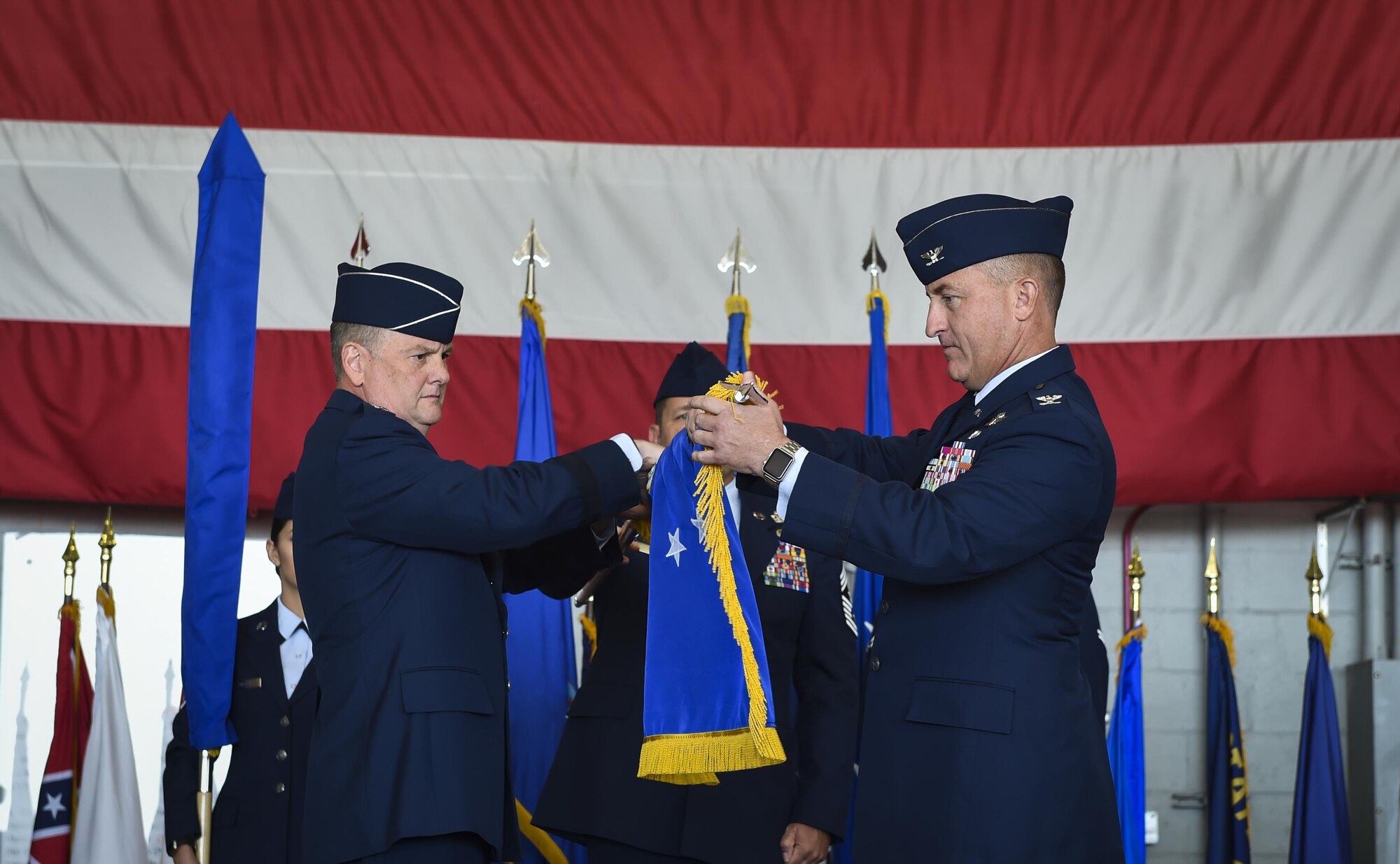 Lt. Gen. Brad Webb, left, the commander of Air Force Special Operations Command, and Col. Nathan Green, right, the commander of Air Force Special Operations Air Warfare Center,  furl the AFSOAWC flag during a ceremony at Hurlburt Field, May 10, 2017. An organizational banner is ceremoniously furled to designate a unit’s inactivation. (U.S. Air Force photo by Airman 1st Class Joseph Pick)