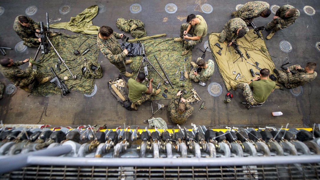 Marines clean weapons in the well deck of the USS Pearl Harbor in the Pacific Ocean, May 6, 2017. The Marines are assigned to the 15th Marine Expeditionary Unit. Navy photo by Petty Officer 3rd Class Tarra Samoluk