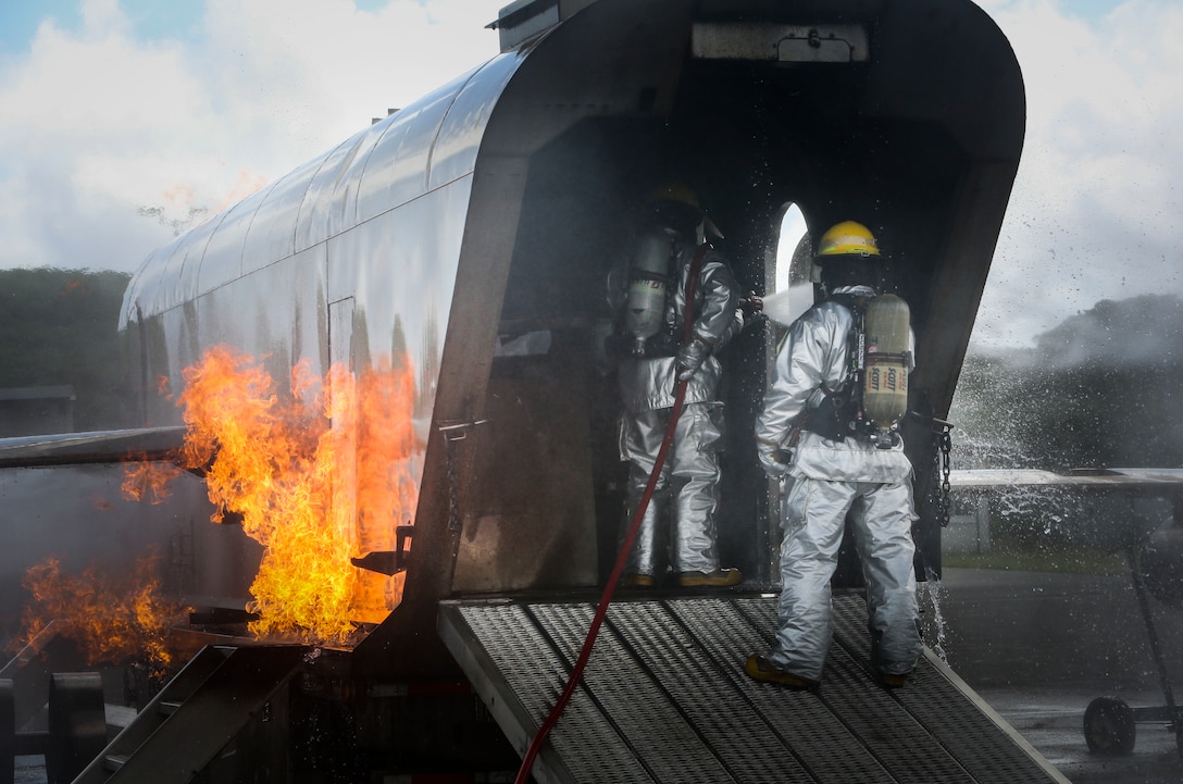 Marines with Aircraft Rescue and Firefighting hose down fires inside of a Mobile Aircraft Firefighting Training Device at Landing Zone Westfield aboard Marine Corps Air Station Kaneohe Bay on May 6, 2017. The purpose of this training is to help ARFF Marines maintain readiness, and be able to effectively extinguish multiple fires in a controlled environment. (U.S. Marine Corps photo by Lance Cpl. Isabelo Tabanguil)