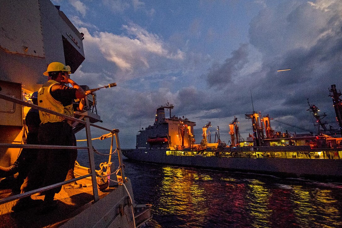 Navy Petty Officer 1st Class Darwin Williams fires a shot line from the  USS Sterett to the USNS John Ericsso to begin an underway replenishment in the South China Sea, May 6, 2017.  Navy photo by Petty Officer 1st Class Byron C. Linder