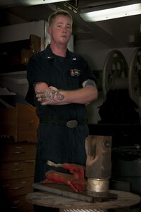 170509-N-XP344-042 MANAMA, Bahrain (May 9, 2017) Mineman 2nd Class Tyler Smith, a native of Munford, Ala. and assigned to the Avenger-class mine countermeasure ship USS Devastator (MCM 6), poses for a photo in front of a nicopress, which makes mechanical or electro-mechanical connections to secure sweep lines. On April 23, Smith deployed to the Avenger-class mine countermeasure ship USS Dextrous (MCM 13) and repaired the ship’s swage, a thick metal clasp that secures the ship’s sweep wire and withstands up to 18,000 pounds of pressure. (U.S. Navy photo by Mass Communication Specialist 2nd Class Victoria Kinney)