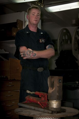 170509-N-XP344-042 MANAMA, Bahrain (May 9, 2017) Mineman 2nd Class Tyler Smith, a native of Munford, Ala. and assigned to the Avenger-class mine countermeasure ship USS Devastator (MCM 6), poses for a photo in front of a nicopress, which makes mechanical or electro-mechanical connections to secure sweep lines. On April 23, Smith deployed to the Avenger-class mine countermeasure ship USS Dextrous (MCM 13) and repaired the ship’s swage, a thick metal clasp that secures the ship’s sweep wire and withstands up to 18,000 pounds of pressure. (U.S. Navy photo by Mass Communication Specialist 2nd Class Victoria Kinney)