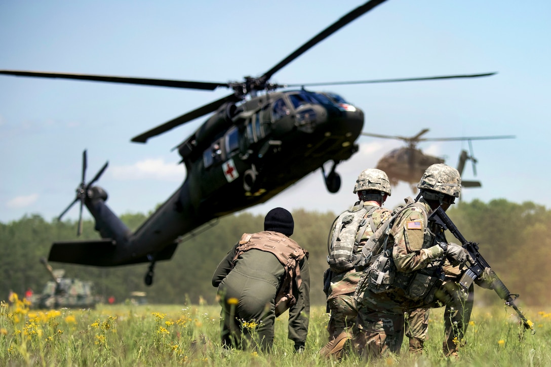 Soldiers and a pilot await the arrival of a UH-60 Black Hawk medevac helicopter during the South Carolina National Guard Air and Ground Expo at McEntire Joint National Guard Base, S.C., May 6, 2017. Army National Guard photo by Sgt. Brian Calhoun