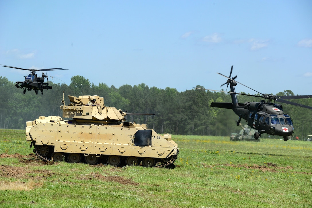 A UH-60 Black Hawk medevac helicopter and an Apache attack helicopter provide aerial support for a Bradley fighting vehicle during the South Carolina National Guard Air and Ground Expo at McEntire Joint National Guard Base, S.C., May 6, 2017. Air National Guard photo by Tech. Sgt. Jorge Intriago