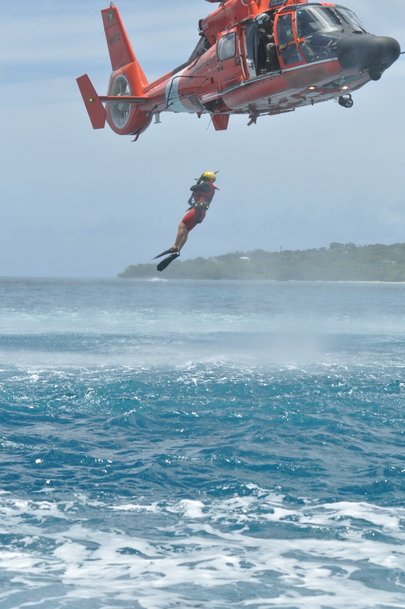 U.S. Coast Guard rescue diver jumps into the water to "rescue" members of the 53rd Weather Reconnaissance Squadron during a joint training between the 53rd WRS and the U.S. Coast Guard, based out of Puerto Rico, in the water survival portion of Survival, Evasion, Resistance, and Escape (SERE) refresher training in the coastal waters of St. Croix, U.S. Virgin Islands, May 8,2017. (U.S. Air Force photo//Master Sgt. Jessica Kendziorek)
