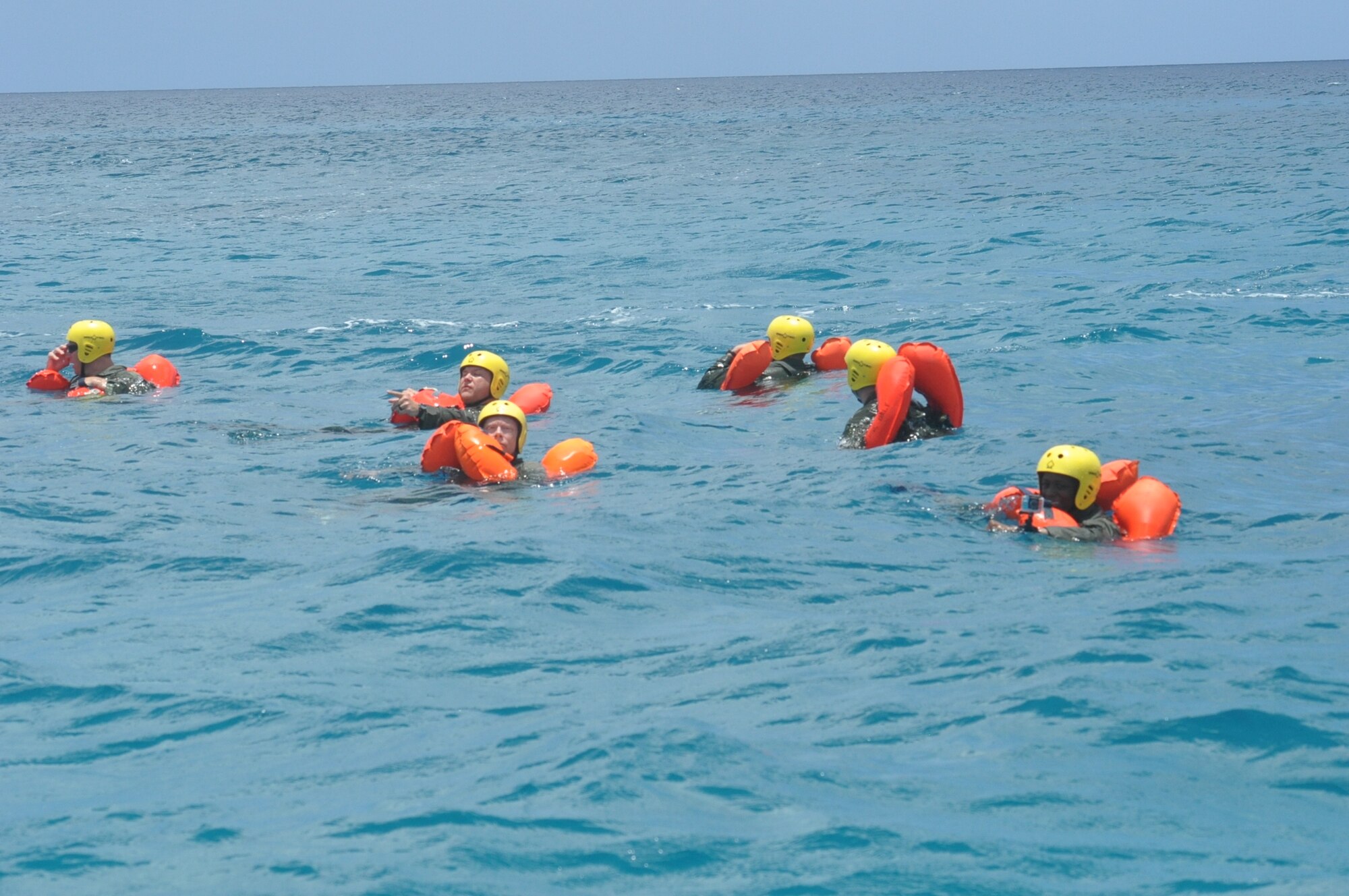 Members of the 53rd Weather Reconnaissance Squadron float at sea, waiting for rescue during joint training between the 53rd WRS and the U.S. Coast Guard, based out of Puerto Rico, in the water survival portion of Survival, Evasion, Resistance, and Escape (SERE) refresher training in the coastal waters of St. Croix, U.S. Virgin Islands, May 8,2017. (U.S. Air Force photo//Master Sgt. Jessica Kendziorek)