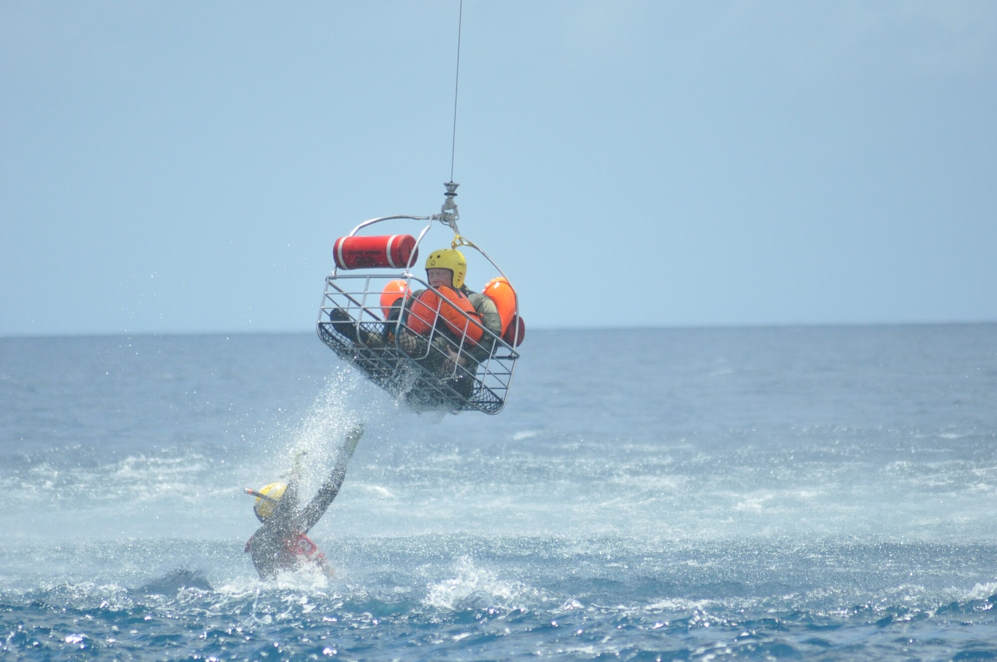 The U.S. Coast Guard diver "rescues" a member of the 53rd Weather Reconnaissance Squadron during joint training between the 53rd WRS and the U.S. Coast Guard, based out of Puerto Rico, in the water survival portion of Survival, Evasion, Resistance, and Escape (SERE) refresher training in the coastal waters of St. Croix, U.S. Virgin Islands, May 8,2017. (U.S. Air Force photo//Master Sgt. Jessica Kendziorek)