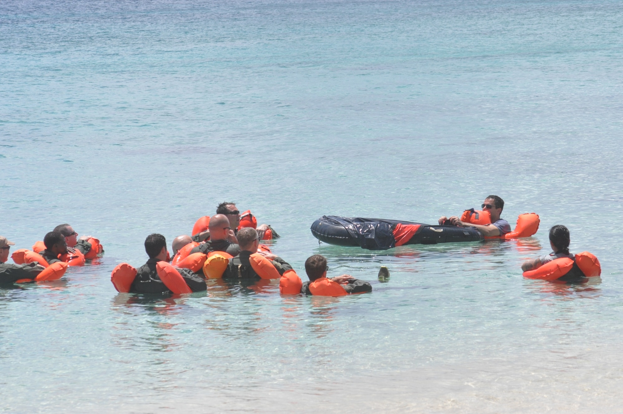 Members of the 53rd Weather Reconnaissance Squadron review how to use and get into a one man life raft during the water survival portion of Survival, Evasion, Resistance, and Escape (SERE) refresher training in the coastal waters of St. Croix, U.S. Virgin Islands, May 8,2017. (U.S. Air Force photo//Master Sgt. Jessica Kendziorek)