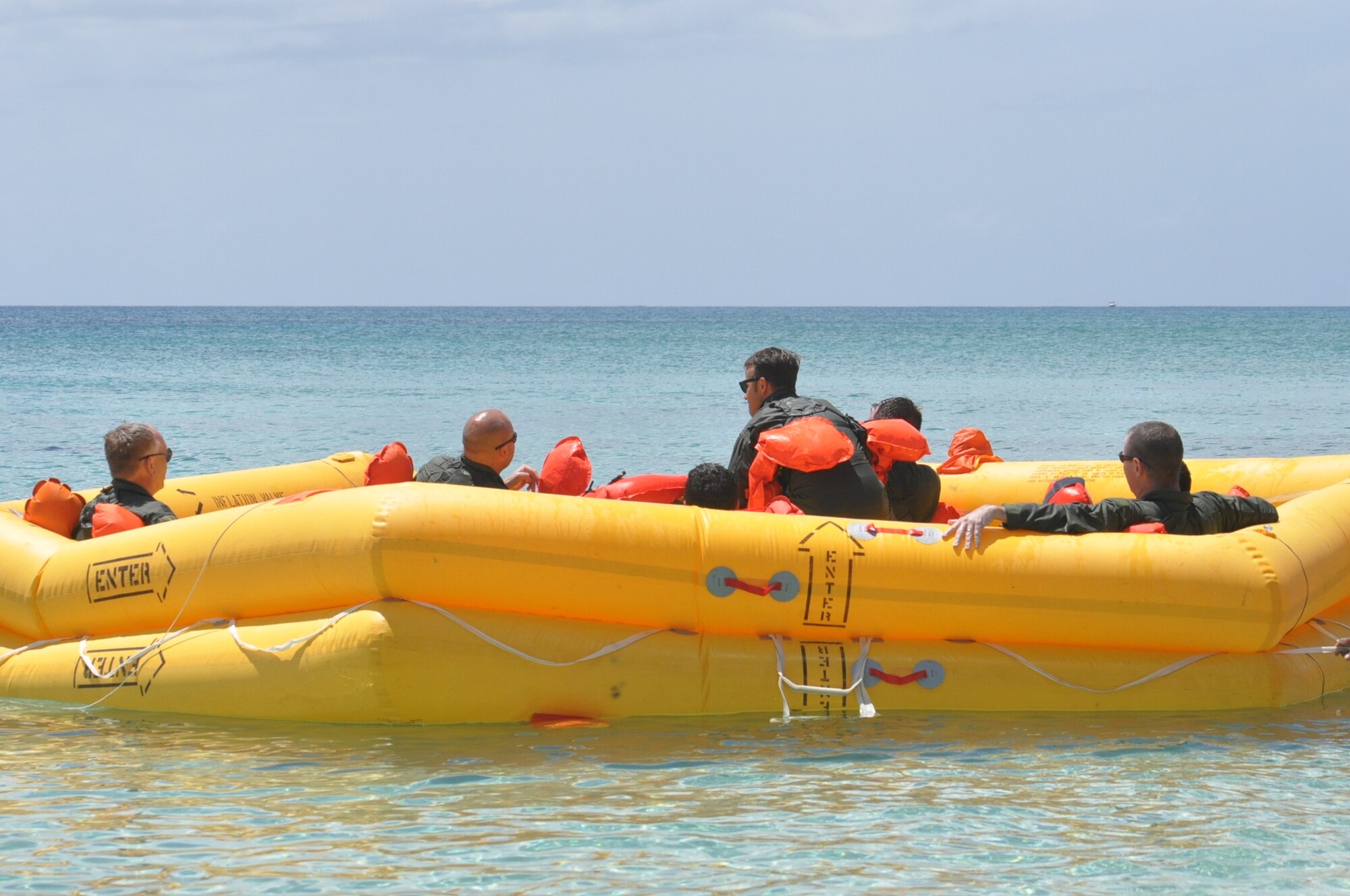 Members of the 53rd Weather Reconnaissance Squadron work together to get into a 46 man life raft during the water survival portion of Survival, Evasion, Resistance, and Escape (SERE) refresher training in the coastal waters of St. Croix, U.S. Virgin Islands, May 8,2017. (U.S. Air Force photo//Master Sgt. Jessica Kendziorek)