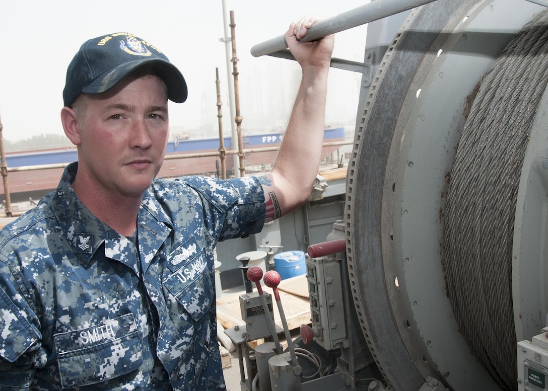 MANAMA, Bahrain (May 9, 2017) Mineman 2nd Class Tyler Smith, a native of Munford, Ala. and assigned to the Avenger-class mine countermeasure ship USS Devastator (MCM 6), poses for a photo in front of Devastator’s sweep line. On April 23, Smith deployed to the Avenger-class mine countermeasure ship USS Dextrous (MCM 13) and repaired the ship’s swage, a thick metal clasp that secures the ship’s sweep wire and withstands up to 18,000 pounds of pressure. (U.S. Navy photo by Mass Communication Specialist 2nd Class Victoria Kinney) 