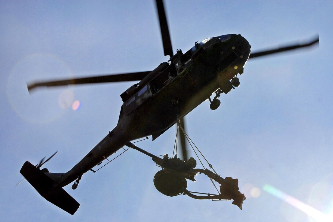 A New York Army National Guard UH-60 Black Hawk helicopter transports  a 105 mm howitzer at Fort Drum, N.Y., to be used during a live-fire exercise, May 4, 2017. The helicopter crew is assigned to the New York Army National Guard's 3rd Battalion, 142nd Aviation Regiment, and transferred twelve 105mm howitzers for the 10th Mountain Division's Alpha Battery, 2nd Battalion, 15th Field Artillery Regiment. New York Army National Guard photo by Master Sgt. Raymond Drumsta