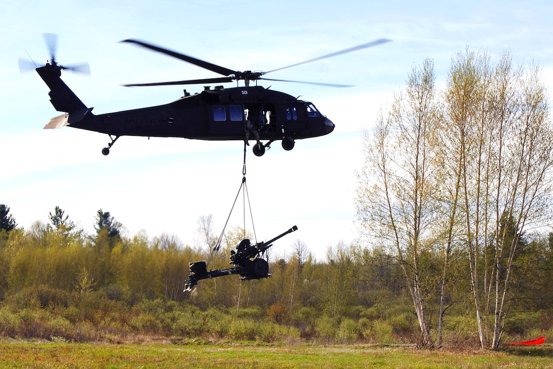 A New York Army National Guard UH-60 Black Hawk helicopter delivers a 105 mm howitzer at Fort Drum, N.Y., to be used during a live-fire exercise, May 4, 2017. The helicopter crew is assigned to the New York Army National Guard's 3rd Battalion, 142nd Aviation Regiment, and transferred twelve 105mm howitzers for the 10th Mountain Division's Alpha Battery, 2nd Battalion, 15th Field Artillery Regiment. New York Army National Guard photo by Master Sgt. Raymond Drumsta
