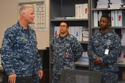 President, Board of Inspection and Survey Rear Adm. Jon Kreitz (left) engages with Electrician’s Mate 1st Class Carlos Genaovargas (center) and Electrician’s Mate 1st Class Ronald Jones (right) during his visit to Southeast Regional Maintenance Center (SERMC). Genaovargas and Jones work in the Outside Electric Shop which repairs, tests, and installs electrical and electronic equipment onboard ships. This image was manipulated using filters to blur portions for security and/or privacy concerns. 