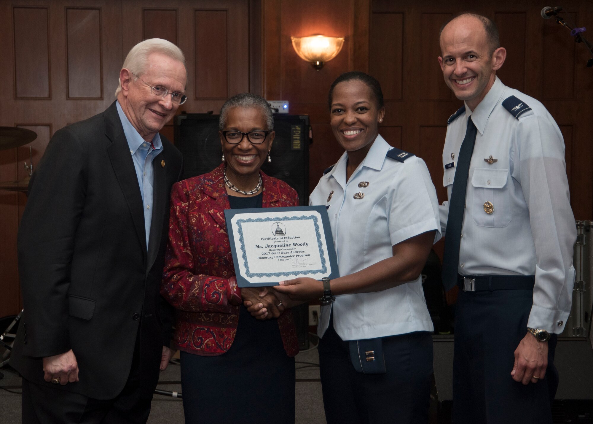 Jacqueline Woody, middle left, Prince George’s County chief of staff senior advisor and special assistant, and honorary commander, receives her induction certificate during the honorary commander ceremony at Joint Base Andrews, Md., May 5, 2017. The community outreach event welcomed, recognized and retired members of the JBA Honorary Commanders Program at different stages of their two-year term. The program, which began in 1999, matches a community leader with a military leader to provide commanders a means to educate participants about the armed forces and their various missions. (U.S. Air Force photo by Senior Airman Jordyn Fetter)