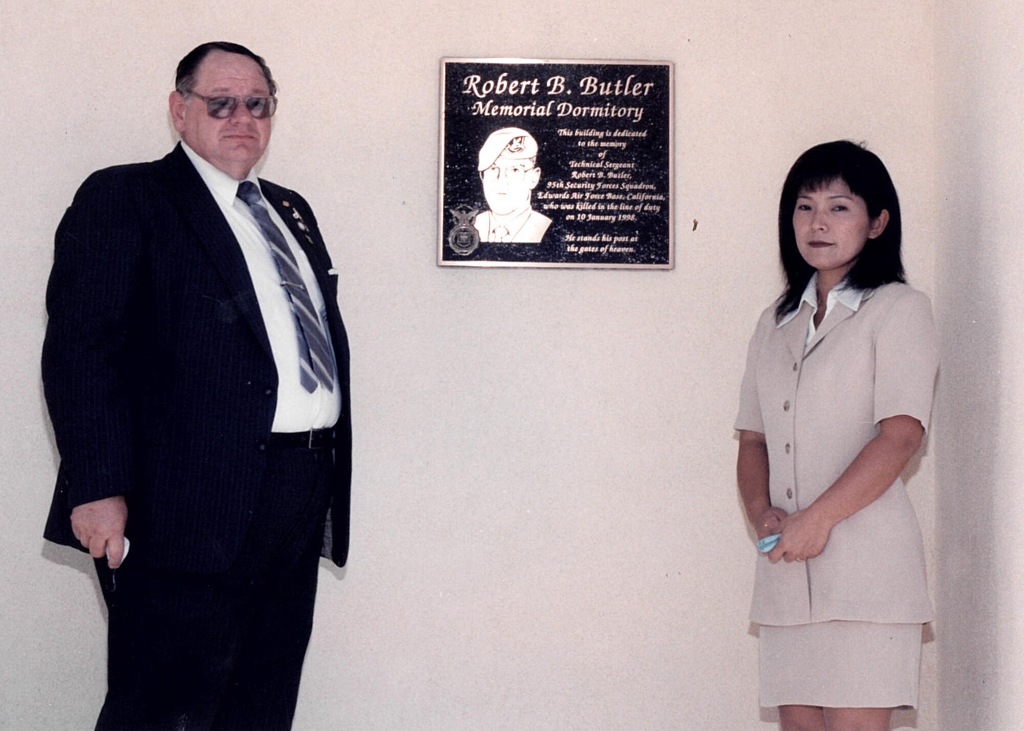 Joseph Butler, father of Tech. Sgt. Robert B. Butler, along with Robert’s wife, Takako Butler, stand in front of a memorial plaque following the dedication of the Tech. Sgt. Robert B. Butler Dorm in July 1998. The dorm is building 2425. (U.S. Air Force photo provided by the Air Force Test Center History Office)