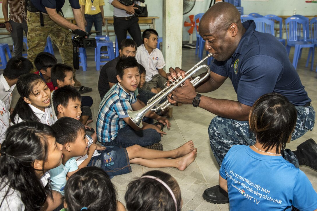 Navy Petty Officer 1st Class Vince Moody plays trumpet with children at the Center for Agent Orange Victims Branch 3 Hoà Nhơn Ward in Danang, Vietnam, May 11, 2017, during Pacific Partnership 2017. Pacific Partnership is an annual multilateral humanitarian assistance and disaster relief preparedness mission in the Indo-Asia-Pacific region. Navy photo by Petty Officer 2nd Class Joshua Fulton